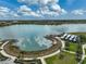 An aerial view of a lakeside club house and community walking trail on a clear day with blue skies at 8261 Grande Shores Dr, Sarasota, FL 34240