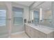 Elegant bathroom with a large vanity, a huge mirror, and tiled shower showcasing modern design at 8261 Grande Shores Dr, Sarasota, FL 34240