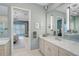 Elegant bathroom with double vanity, marble countertops, and a view into the primary bedroom at 8261 Grande Shores Dr, Sarasota, FL 34240