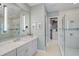 Bright bathroom with a double vanity, walk-in shower, and access to a large walk-in closet at 8261 Grande Shores Dr, Sarasota, FL 34240