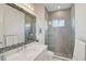 Modern bathroom featuring a large mirror, a white vanity, a tiled shower, and natural light at 8261 Grande Shores Dr, Sarasota, FL 34240