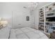 Bright bedroom featuring white walls, a built-in bookshelf, modern lighting, and ample closet space at 8261 Grande Shores Dr, Sarasota, FL 34240