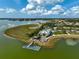 Aerial shot of a community clubhouse with a dock on the lake surrounded by lush greenery at 8261 Grande Shores Dr, Sarasota, FL 34240