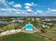 Aerial view of a community pool area with lounge chairs next to a lake in a beautiful neighborhood at 8261 Grande Shores Dr, Sarasota, FL 34240