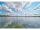 Scenic lake view with calm waters and blue sky reflecting, showcasing the peaceful community setting at 8261 Grande Shores Dr, Sarasota, FL 34240