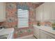 Bright laundry room with patterned wallpaper, modern appliances, white cabinetry, and ample counter space at 8261 Grande Shores Dr, Sarasota, FL 34240