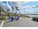 Outdoor patio with comfortable seating around a fire pit, overlooking the lake and landscaped grounds at 8261 Grande Shores Dr, Sarasota, FL 34240