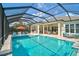 A long screened pool with an umbrella table is surrounded by ample seating space at 8261 Grande Shores Dr, Sarasota, FL 34240