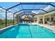 A long screened pool with an umbrella table is surrounded by ample seating space at 8261 Grande Shores Dr, Sarasota, FL 34240