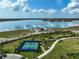 Overhead shot of tennis court in community with water view and recreational area at 8261 Grande Shores Dr, Sarasota, FL 34240