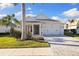 Single-story home with a white exterior, two-car garage and landscaping at 883 Seascape Pl, Sarasota, FL 34240