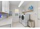 Laundry room with modern washer and dryer, cabinets and counter space at 883 Seascape Pl, Sarasota, FL 34240