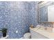 Stylish powder room with blue floral wallpaper and a white vanity at 883 Seascape Pl, Sarasota, FL 34240