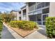 Landscaped walkway leading to condo building with screened patio at 8901 Veranda Way # 116, Sarasota, FL 34238