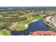 Aerial view of a lush golf course with a pond and surrounding landscape at 8901 Veranda Way # 116, Sarasota, FL 34238