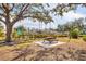 Relaxing picnic area with a shaded table and view of tennis court at 8901 Veranda Way # 116, Sarasota, FL 34238