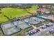 Aerial view showing multiple tennis courts, a pool, and clubhouse at 8901 Veranda Way # 116, Sarasota, FL 34238