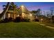 Modern home with a sloped lawn and palm trees at dusk at 10106 46Th W Ave, Bradenton, FL 34210