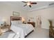 Bright bedroom featuring a ceiling fan, tray ceiling, and en suite bathroom entrance at 10234 Craftsman Park Way, Palmetto, FL 34221