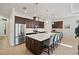 Modern kitchen boasts a large island with seating, stainless steel appliances, and dark wood cabinetry at 10234 Craftsman Park Way, Palmetto, FL 34221