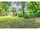 Spacious backyard with lush landscaping and a screened patio at 1101 Anclote Blvd, Tarpon Springs, FL 34689