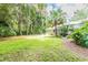 Large backyard with tropical landscaping and screened enclosure at 1101 Anclote Blvd, Tarpon Springs, FL 34689