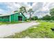 Green barn with open stall doors and gravel driveway at 1101 Anclote Blvd, Tarpon Springs, FL 34689