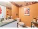Small bathroom with sink, toilet, and equestrian decor at 1101 Anclote Blvd, Tarpon Springs, FL 34689