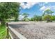 Sandy riding arena with jumps, surrounded by trees at 1101 Anclote Blvd, Tarpon Springs, FL 34689
