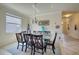 Spacious dining room with glass table and view into the kitchen and entryway at 11698 Anhinga Ave, Venice, FL 34292