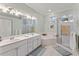 Large bathroom with double sinks, a soaking tub, and a walk-in shower at 11921 Whistling Way, Lakewood Ranch, FL 34202