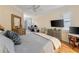 Spacious bedroom with a king bed, hardwood floors, and a TV at 11921 Whistling Way, Lakewood Ranch, FL 34202