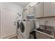 Laundry room with washer, dryer, and utility sink at 11921 Whistling Way, Lakewood Ranch, FL 34202