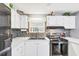 White kitchen cabinets, updated backsplash, and modern stove at 1210 41St Avenue E Dr, Ellenton, FL 34222
