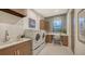 Convenient laundry room with washer, dryer, and built-in workspace at 1210 Blue Shell Loop, Sarasota, FL 34240