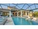 Luxury pool and patio area with outdoor kitchen, lounge area and covered lanai at 1210 Blue Shell Loop, Sarasota, FL 34240