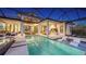 Evening view of the pool, patio, and outdoor kitchen area at 1210 Blue Shell Loop, Sarasota, FL 34240