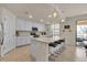 Modern kitchen with white cabinets, island, and breakfast bar at 12550 Ghiberti Cir # 101, Venice, FL 34293