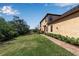 Landscaped side yard with brick walkway leading to back of house at 12550 Ghiberti Cir # 101, Venice, FL 34293