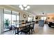 Dining area with glass-top table and chairs, open to living room at 1737 Bonitas Cir # 1724D, Venice, FL 34293