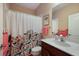 Bathroom with shower/tub, vanity, and floral curtain at 176 Avens Dr, Nokomis, FL 34275