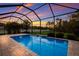 Enclosed pool with water feature at sunset at 176 Avens Dr, Nokomis, FL 34275