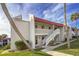 Two-story condo building with red roofs, white walls, and palm trees at 1801 Gulf N Dr # 121, Bradenton Beach, FL 34217