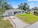 Charming single-story home with well-manicured lawn, long driveway, and neutral exterior paint at 2102 Alaric St, Port Charlotte, FL 33952