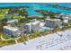 Aerial view of beachfront property with resort amenities, including pools and parking at 250 Sands Point Rd # 5105, Longboat Key, FL 34228