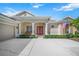Elegant front entry with red double doors and white columns at 4790 Sweetshade Dr, Sarasota, FL 34241
