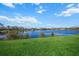 Serene lake view with lush green grass and clear blue sky at 4790 Sweetshade Dr, Sarasota, FL 34241