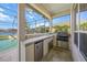 Outdoor kitchen with a grill and mini fridge next to the pool at 4790 Sweetshade Dr, Sarasota, FL 34241