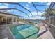 Inviting pool and spa with screened enclosure, overlooking a serene lake at 4790 Sweetshade Dr, Sarasota, FL 34241