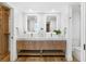 Bright bathroom with double vanity, wooden cabinets, gold hardware, and a closet at 4822 Ocean Blvd # 8C, Sarasota, FL 34242
